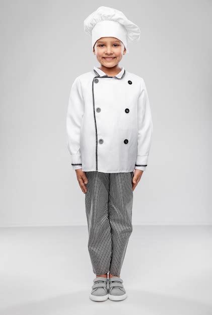 Smiling little girl in chefs toque and jacket | Premium Photo