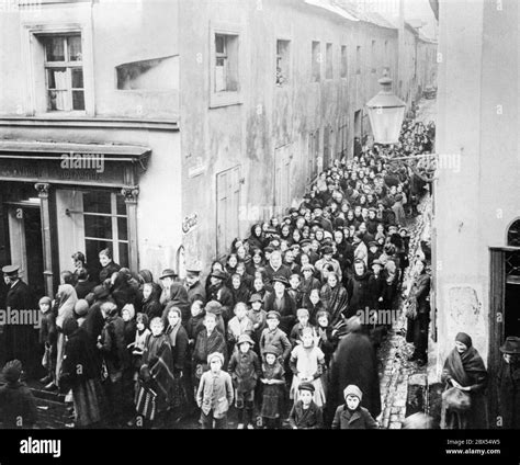 A long queue has formed in front of a bakery in an alley. People are ...