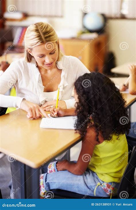 Helping Her with Her Homework. a Young Teacher Helping Children with Their Work. Stock Image ...