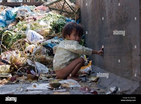 A young girl is defecating in a dumpster filled with garbage on a Stock ...