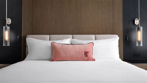 JW Marriott bed in hotel room with logo on an accent pillow