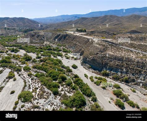 Dry landscape with hills and river valleys under a sunny sky, aerial ...