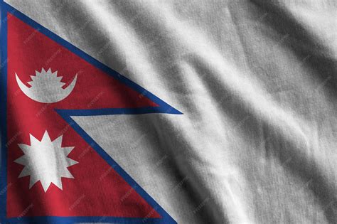 Bandera de nepal con grandes pliegues ondeando de cerca bajo la luz del ...