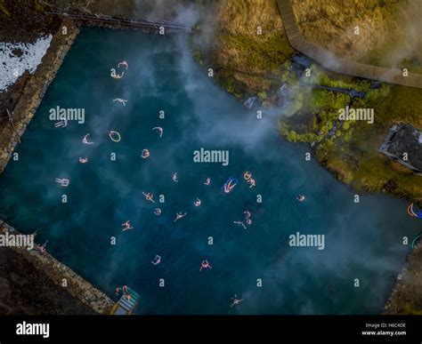 Aerial-People swimming in a natural hot spring- The Secret Lagoon ...