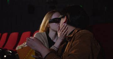 在电影院里看电影亲吻的情侣-国外素材网