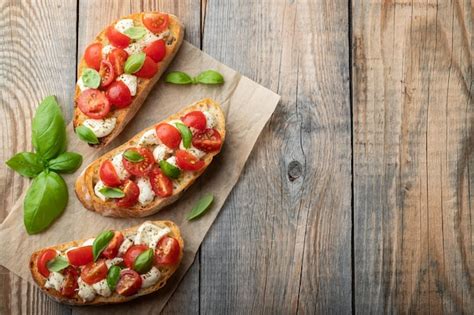 Bruschetta mit Tomaten, Mozzarella-Käse und Basilikum auf einem alten ...