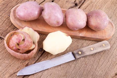 Stack of potatoes on wooden table solanum tuberosum | Premium Photo