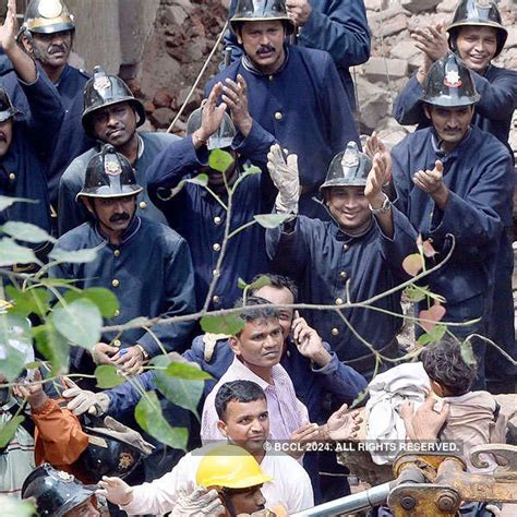 Indian Fire officials rescues an injured person from debris of a ...