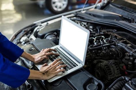 Hands of female mechanic using laptop | Free Photo