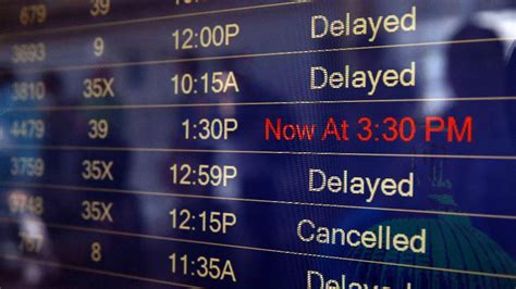 Passengers look at flight delays on a departure board at Orlando International Airport on November 0