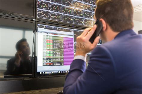 用手机交易股票的商人股票分析师在多个计算机屏幕上查看图表索引和数字股票交易员高清图片下载-正版图片502743581-摄图网