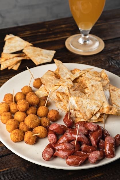 Beer appetizer assorted in a plate on a wooden table | Premium Photo