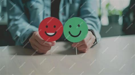 Hands holding up red and green emoji faces with smiling expressions evoking a sense of ...