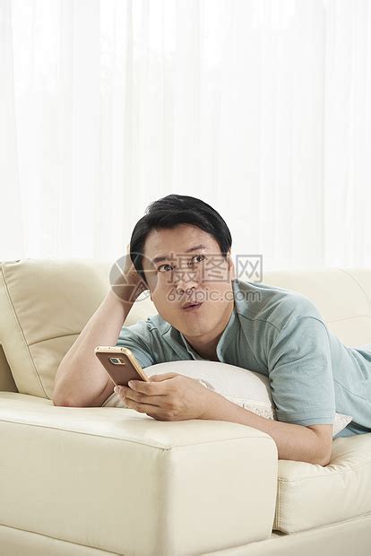 躺在沙发上玩手机的中年男人高清图片下载-正版图片502113340-摄图网