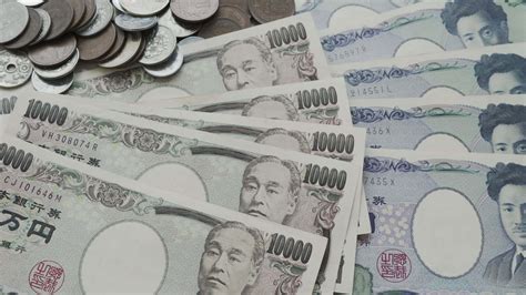 A close up of the Japanese yen on a wooden table.The yen is the currency of Japan that is used ...