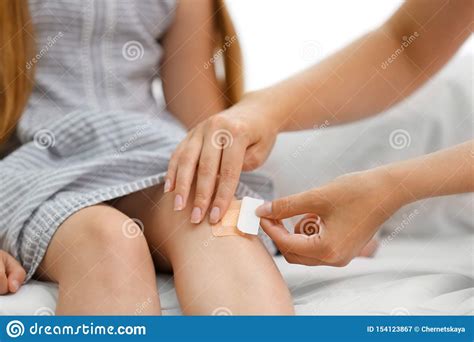 Woman Applying Plaster On Girl`s Knee Stock Image - Image of adhesive, girl: 154123867