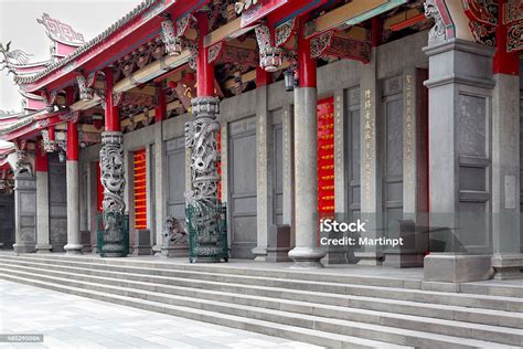 Photo of an elaborate Chinese temple with hedges in front.