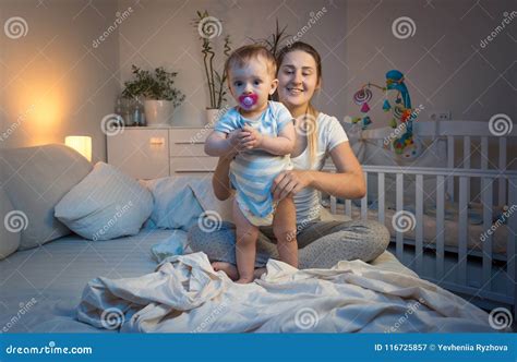 Portrait of Sleepy Tired Young Mother Changing Her Baby`s Diapers at ...
