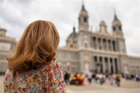 Tourist woman looking at the imposing facade of the almudena cathedral ...