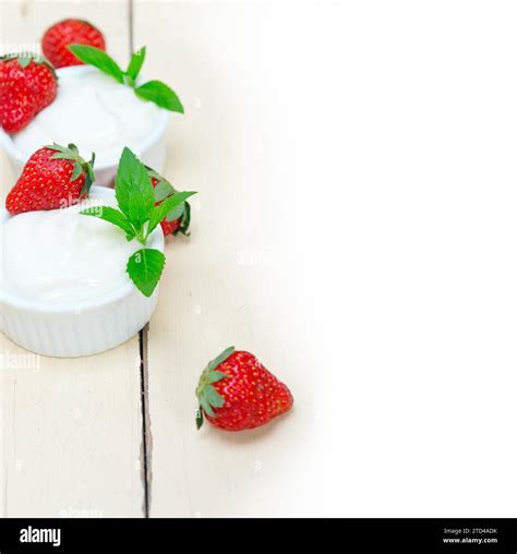 Organic Greek yogurt and strawberry over white rustic wood table Stock ...