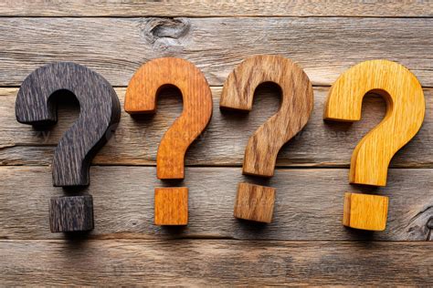 Four wooden question marks on rustic wood background posing important ...