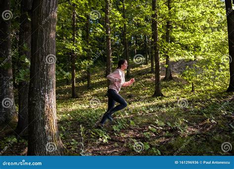 Young Girl Jogging in the Woods on a Sunny Morning. Stock Photo - Image ...