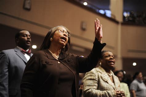 A woman sings as parishioners gather for a Sunday morning worship ...