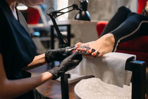 戴黑手套的美容师对顾客做足疗高清图片下载-正版图片302545179-摄图网