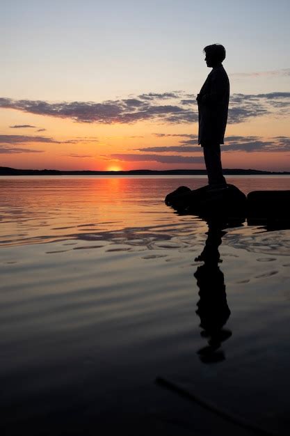 Sad and contemplative person near lake | Free Photo