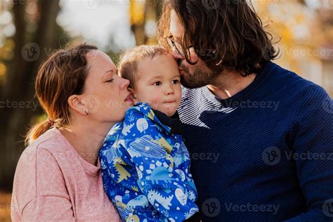 en un soleado otoño día en el parque, un madre y padre cariñosamente ...