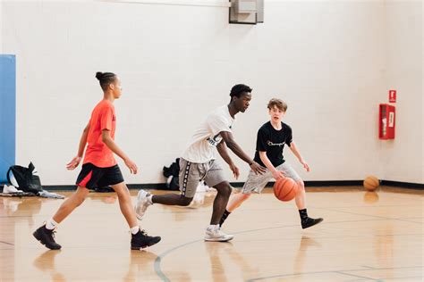 Group of teenage boys playing basketball in the Briggs YMCA Gymnasium.