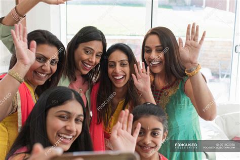 Happy Indian women and girls in saris and bindis taking selfie — mother ...