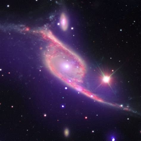 Nested in Pavo, the Peacock constellation, two galaxies are merging ...