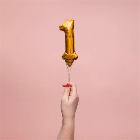 Female hand holding a number birthday anniversary celebration gold ...