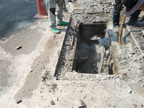 工人挖掘下水道以修复地下公用事业服务电缆高清摄影大图-千库网