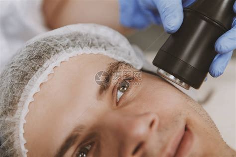 一名男子在水疗中心接受面部护肤治疗的特写专业美容师在男客户脸上进行微晶换肤术复兴高清图片下载-正版图片506012071-摄图网
