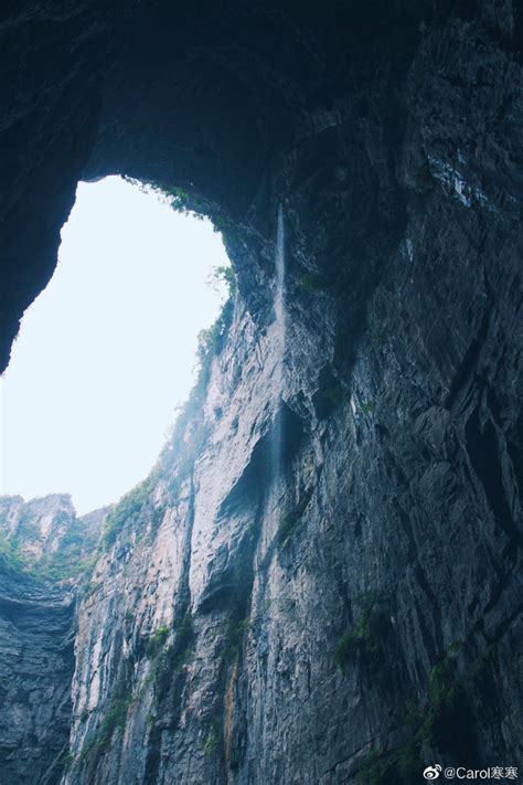 the view from inside a cave looking down at a river and mountains in ...