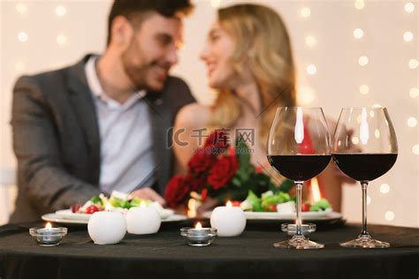 有爱心的夫妻在餐馆约会，有红葡萄酒的眼镜在前头高清摄影大图-千库网