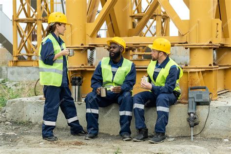 Group of builders talking while having lunch on construction site ...