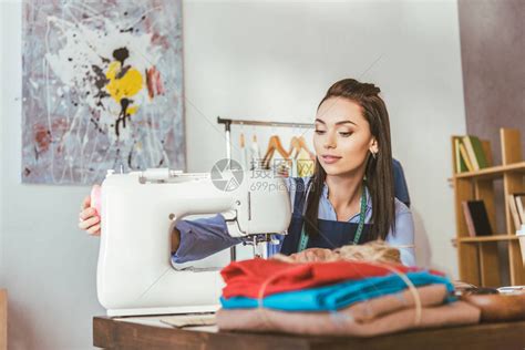 快乐的女裁缝用白色缝纫机缝制面料高清图片下载-正版图片505050601-摄图网