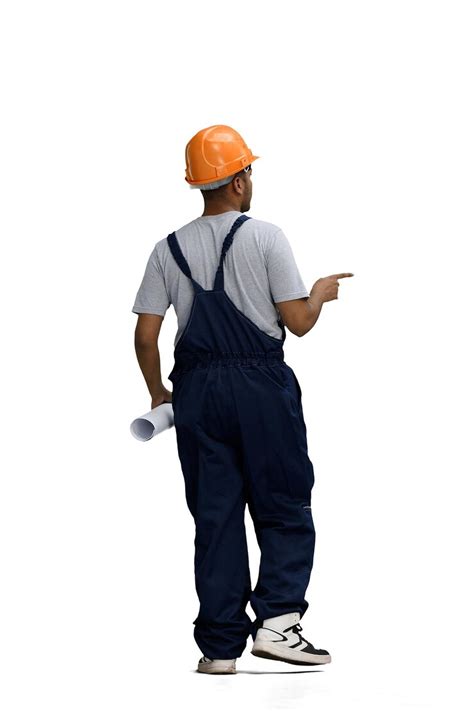 A man in a work uniform on a white background points to the side back ...