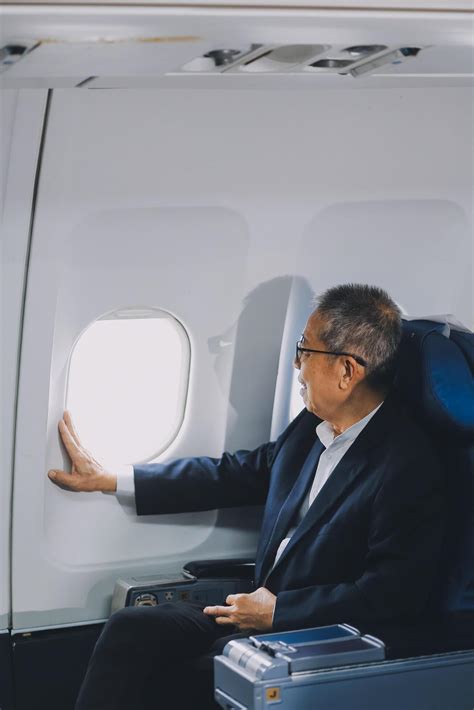 Attractive Asian male passenger of airplane sitting in comfortable seat ...