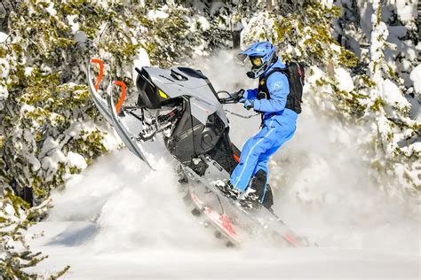 Rider riding up a snowy mountain on the 2027 Ski-Doo Summit