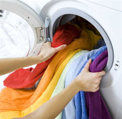 洗衣机洗衣服图片-用洗衣机洗衣服的戴着女儿的家庭主妇素材-高清图片-摄影照片-寻图免费打包下载