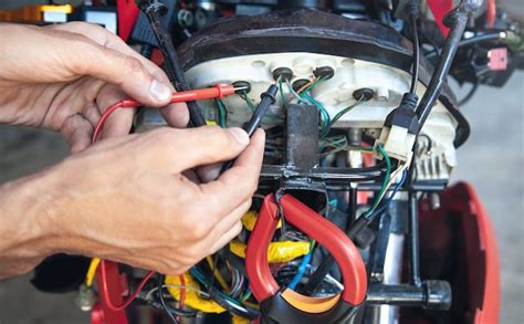 Mechanic man wiring the electrical cables motorcycle. | Premium Photo