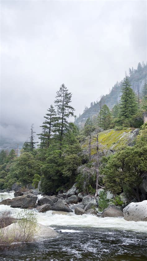 Merced River flowing through Yosemite national park on a cloudy spring day, California, USA ...