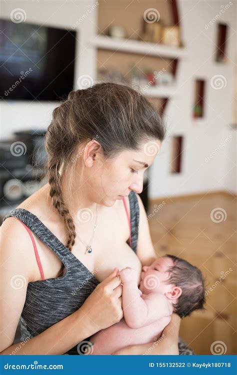 Breast-feeding. Breastfeeding Their Newborn Girl at Home Stock Photo ...
