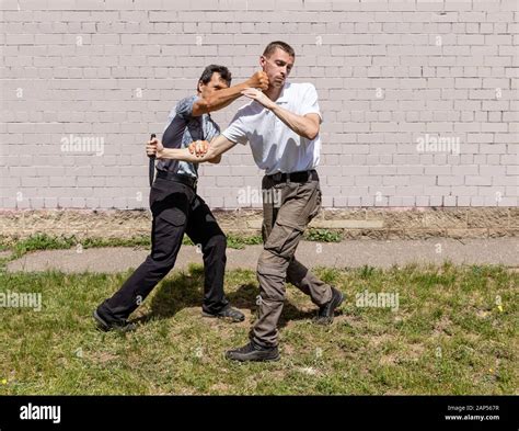 Mature male instructor strikes in the face of an attacker with a knife ...