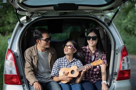 Happy little girl with asian family sitting in the car | Premium Photo