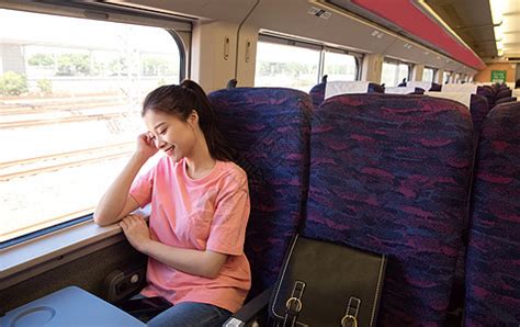 一个女人把她的行李放在火车网格车厢提升通勤者照片摄影图片_ID:313607502-Veer图库